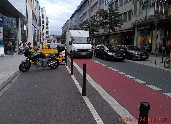 Das Bild zeigt die Fressgasse, mit einem parkenden Lieferwagen auf der Radspur
